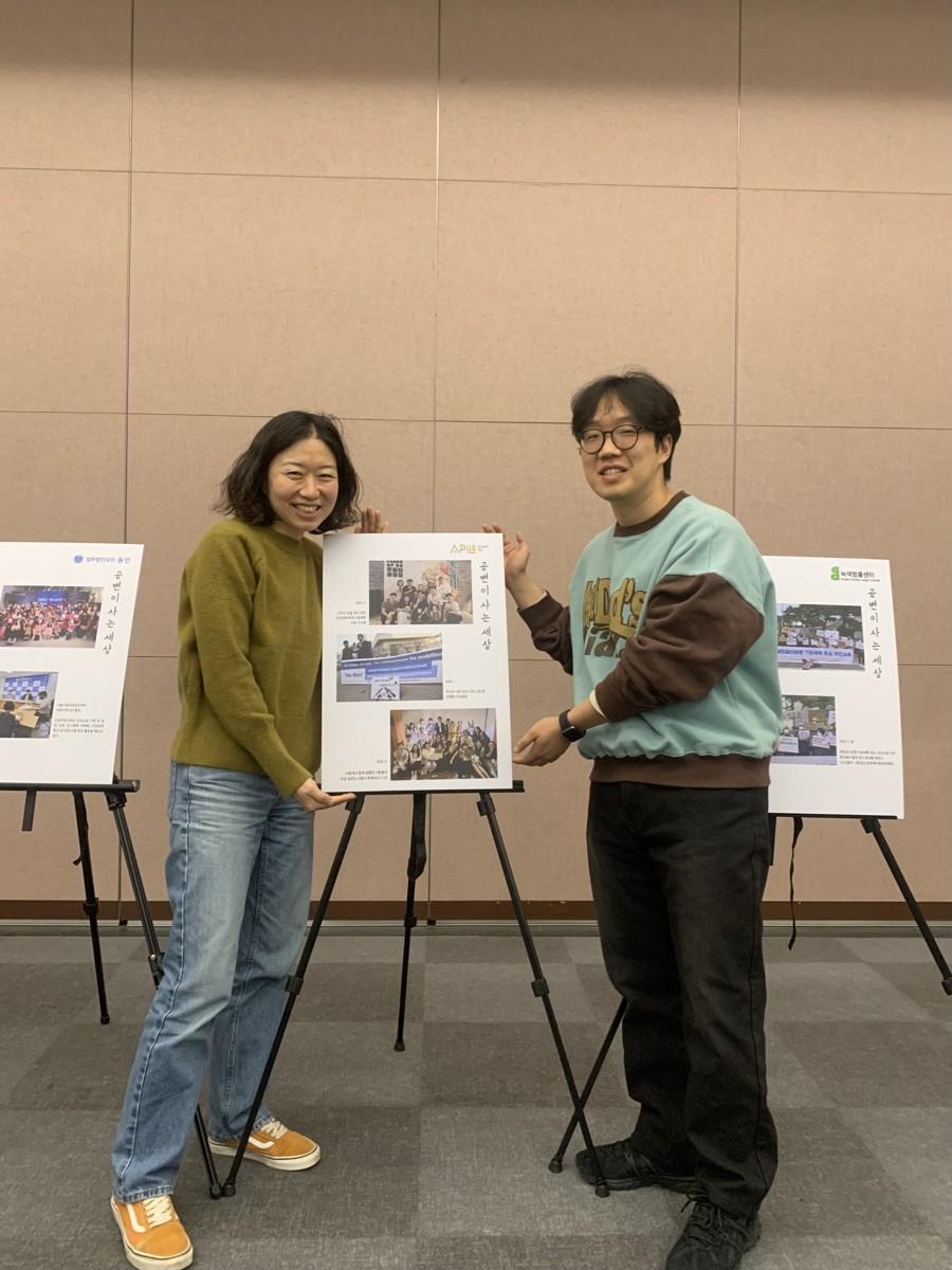 법조공익모임 나우 행사에 전시된 어필 포스터 앞에 서있는 어필의 정신영 변호사, 김주광 변호사